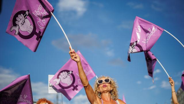 Eine Frau schwenkt auf einer Demonstration gegen den ehemaligen spanischen Fußballfunktionär Rubiales am 1. September 2023 in Madrid eine rosafarbene Fahne mit dem Symbol der Frauenbewegung. 