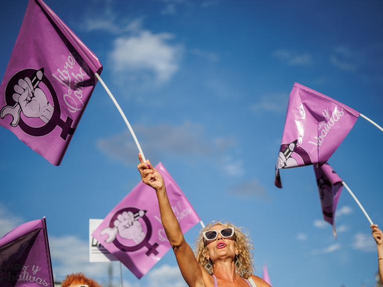 Eine Frau schwenkt auf einer Demonstration gegen den ehemaligen spanischen Fußballfunktionär Rubiales am 1. September 2023 in Madrid eine rosafarbene Fahne mit dem Symbol der Frauenbewegung. 