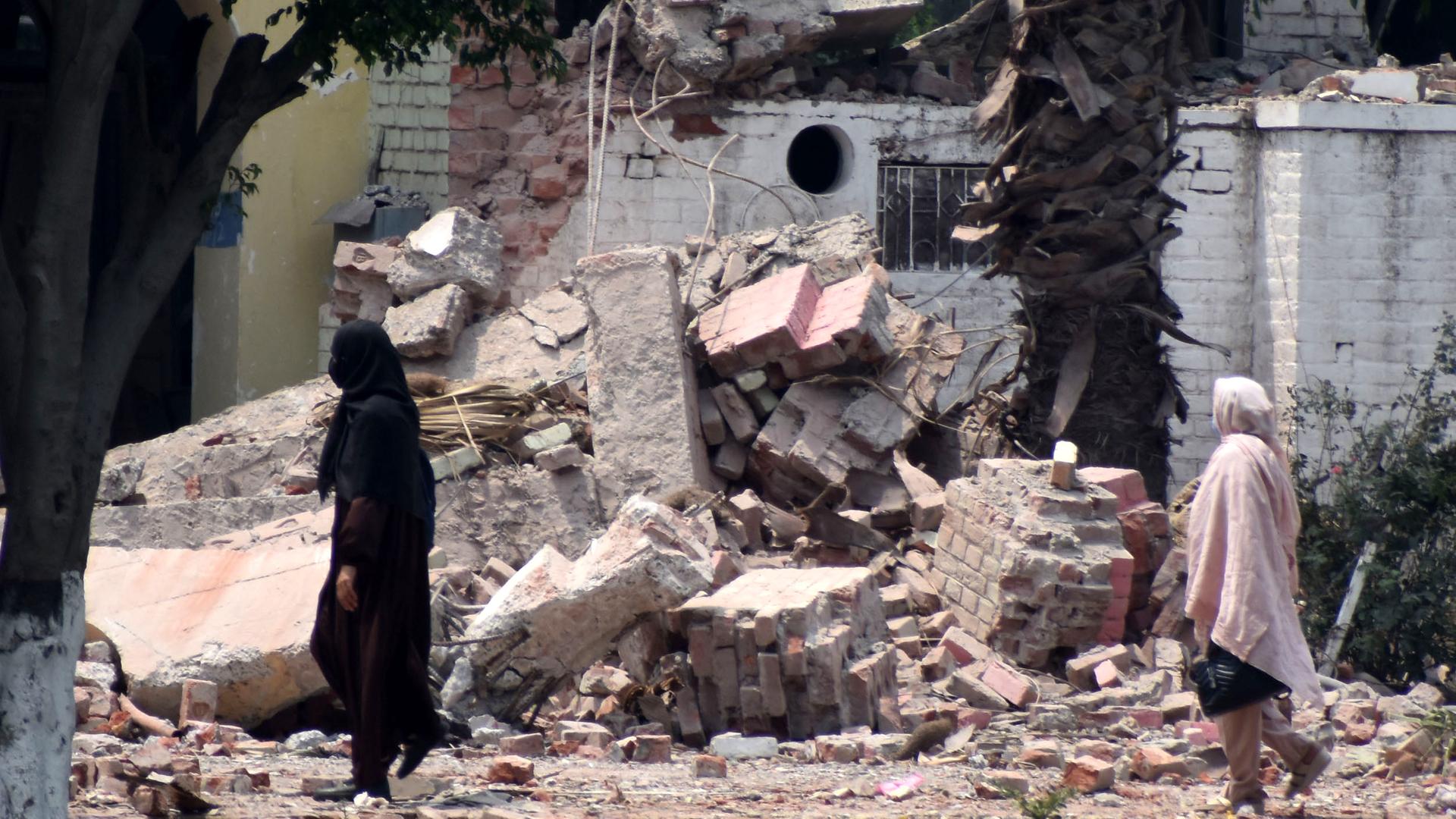 Frauen gehen durch die Trümmer eines zerstörten Gebäudes nach einem indischen Raketenangriff in Muridke, einer Stadt in der Nähe von Lahore, in Pakistan. Frauen gehen durch die Trümmer eines zerstörten Gebäudes nach einem indischen Raketenangriff in Muridke, einer Stadt in der Nähe von Lahore, in Pakistan.