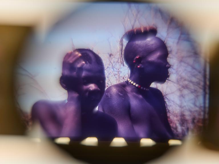 Dias aus dem Nachlass von Leni Riefenstahl mit der Beschriftung "Landschaft mit Nuba", im Depot des Museum für Fotografie in Berlin. Zwei Nuba sind in einem kreisrunden Ausschnitt zu sehen. 