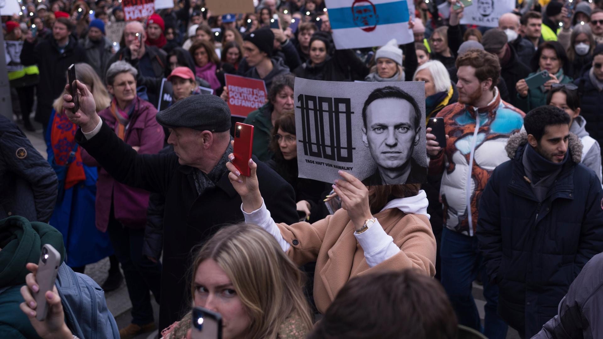 Menschen demonstrieren in der Nähe der russischen Botschaft in Berlin. Einige halten Bilder des in einem russischen Straflager gestorbenen Oppositionspolitikers Alexej Nawalny hoch.