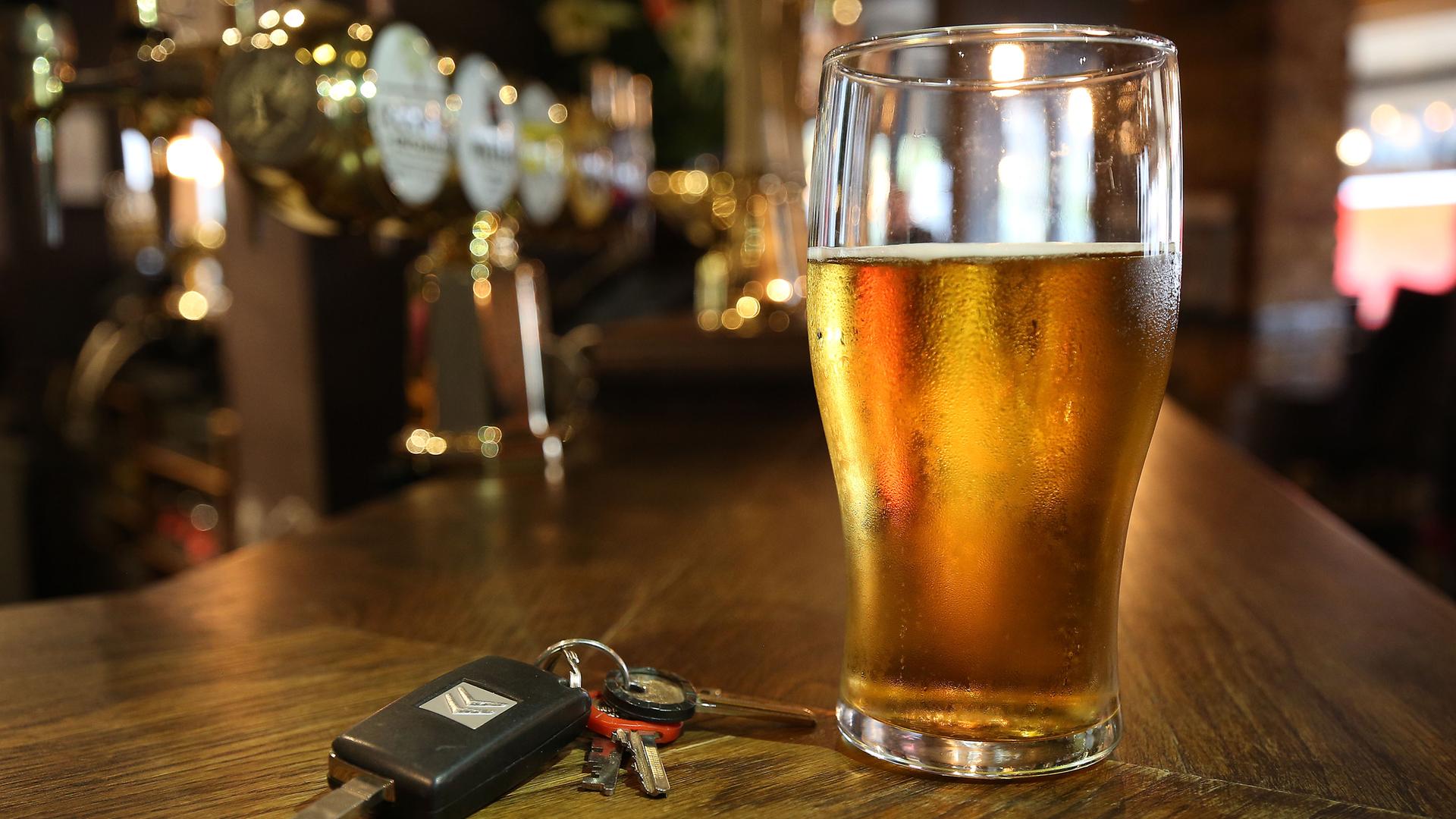 Ein Glas Bier und ein Autoschlüssel auf einer Theke 