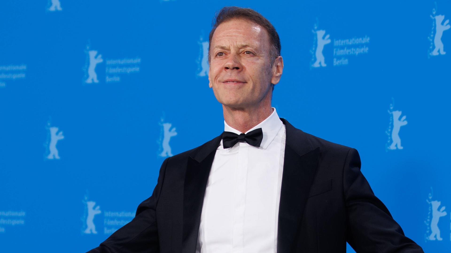 Rocco Siffredi steht vor der blauen Berlinale-Wand, trägt einen schwarzen Anzug und Fliege