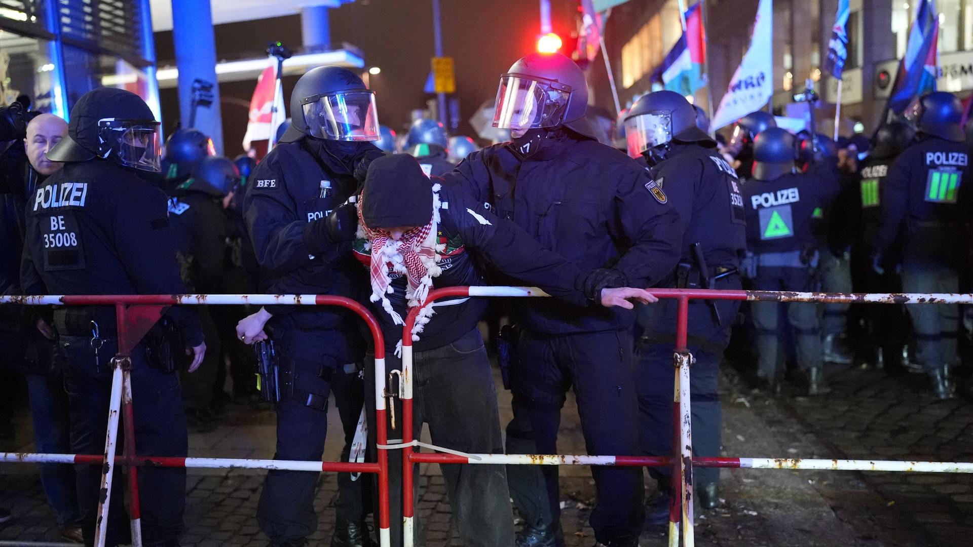 Polizisten führen einen Demonstranten ab. 