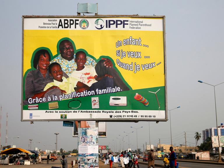 Auf einer Werbetafel auf einer belebten Strasse ist eine Familie abgebildet, darunter verschiedene Verhütungsmethoden.