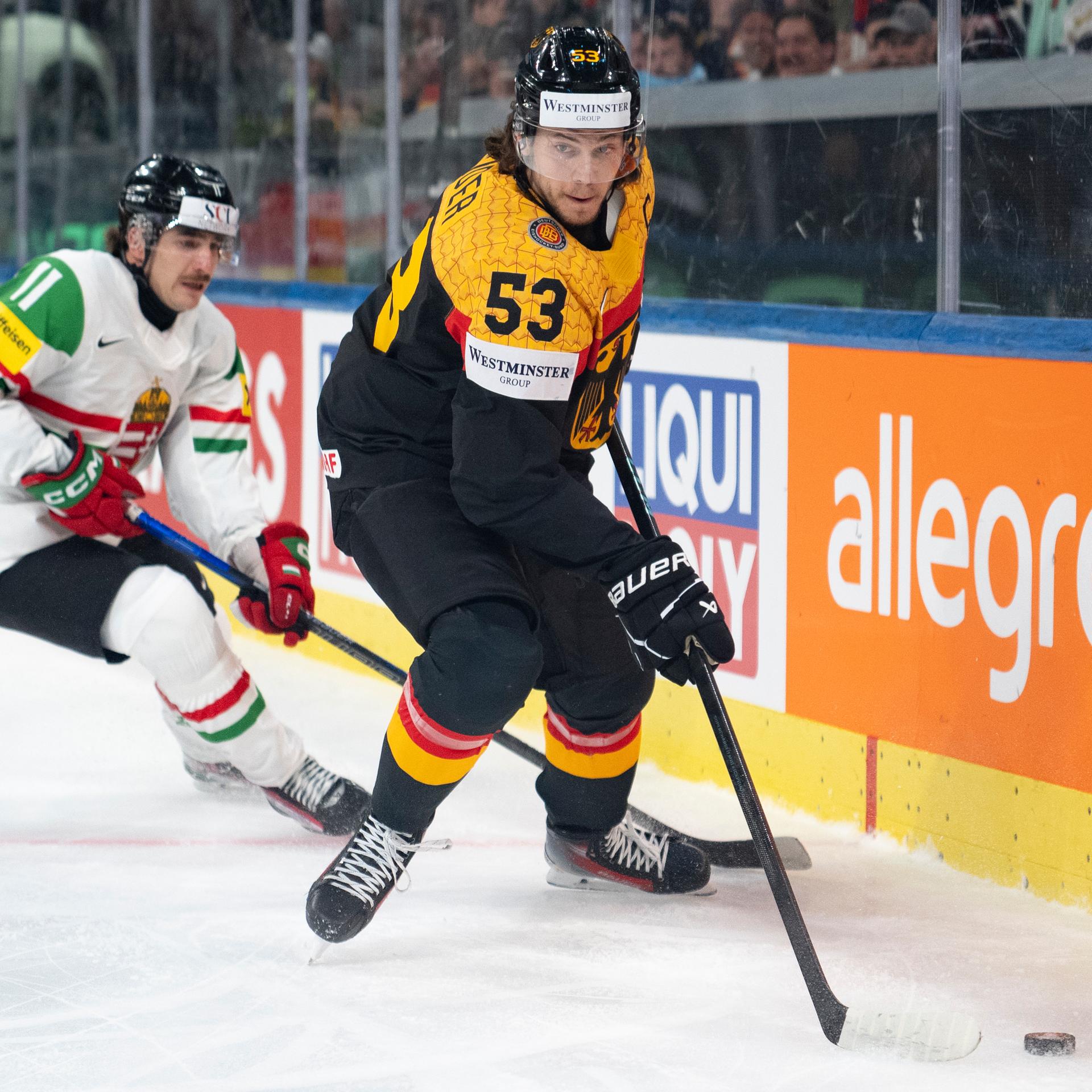 Deutschlands Spieler Moritz Seider kämpft mit dem ungarischen Nationalspieler Bence Horvath um den Puck.