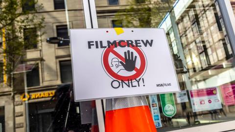 An einer Glastür ist ein Stoppschild mit der Aufschrift "Filmcrew Only!" angebracht.