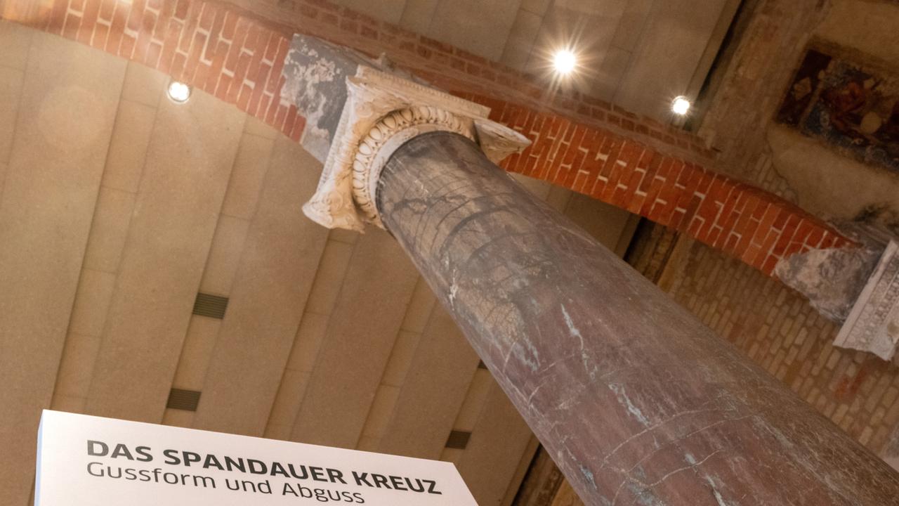 Ein Plakat mit Abbildungen weist im Museum für Vor- und Frühgeschichte des Neuen Museums auf die Gussform und den Abguss des Spandauer Kreuzanhängers aus dem 11. Jahrhundert hin. 