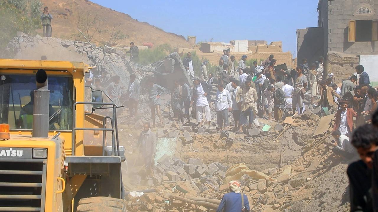 Das Bild zeigt Menschen in einer vom Krieg gezeichneten Trümmerlandschaft.