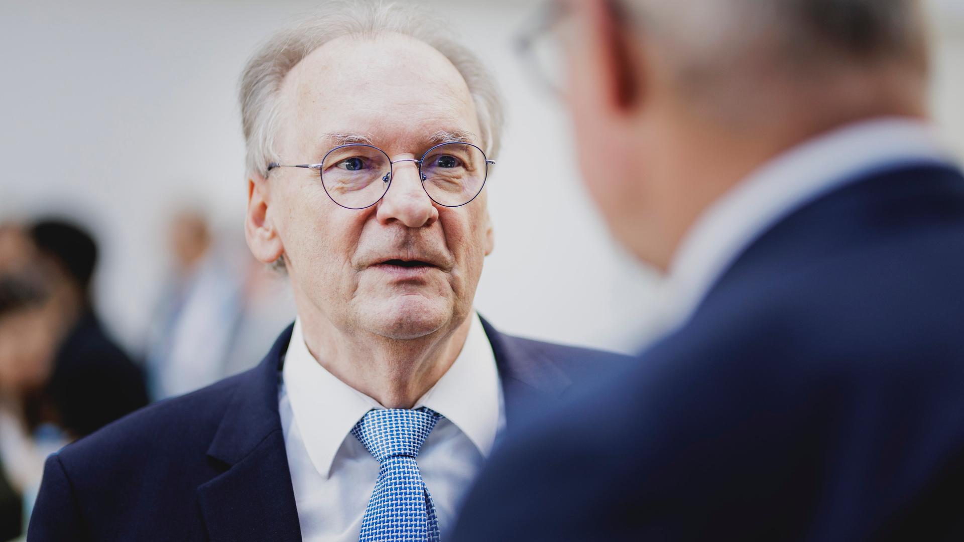 Der Ministerpräsident von Sachsen-Anhalt Reiner Haseloff (CDU) im Anzug unterhält sich mit einer Person