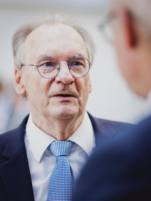 Der Ministerpräsident von Sachsen-Anhalt Reiner Haseloff (CDU) im Anzug unterhält sich mit einer Person