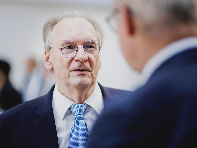 Der Ministerpräsident von Sachsen-Anhalt Reiner Haseloff (CDU) im Anzug unterhält sich mit einer Person