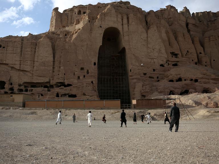 Ein Fußballfeld vor dem Berg , in dem einst die Buddha-Statuen standen 