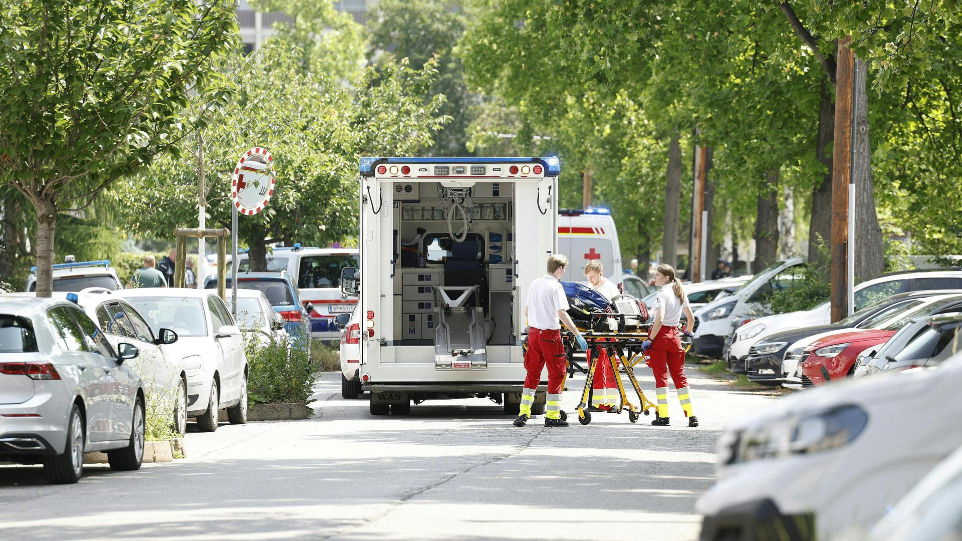Auf einer Straße steht ein Rettungswagen, davor fahren Rettungskräfte eine Krankenliege. Auf einer Straße steht ein Rettungswagen, davor fahren Rettungskräfte eine Krankenliege.