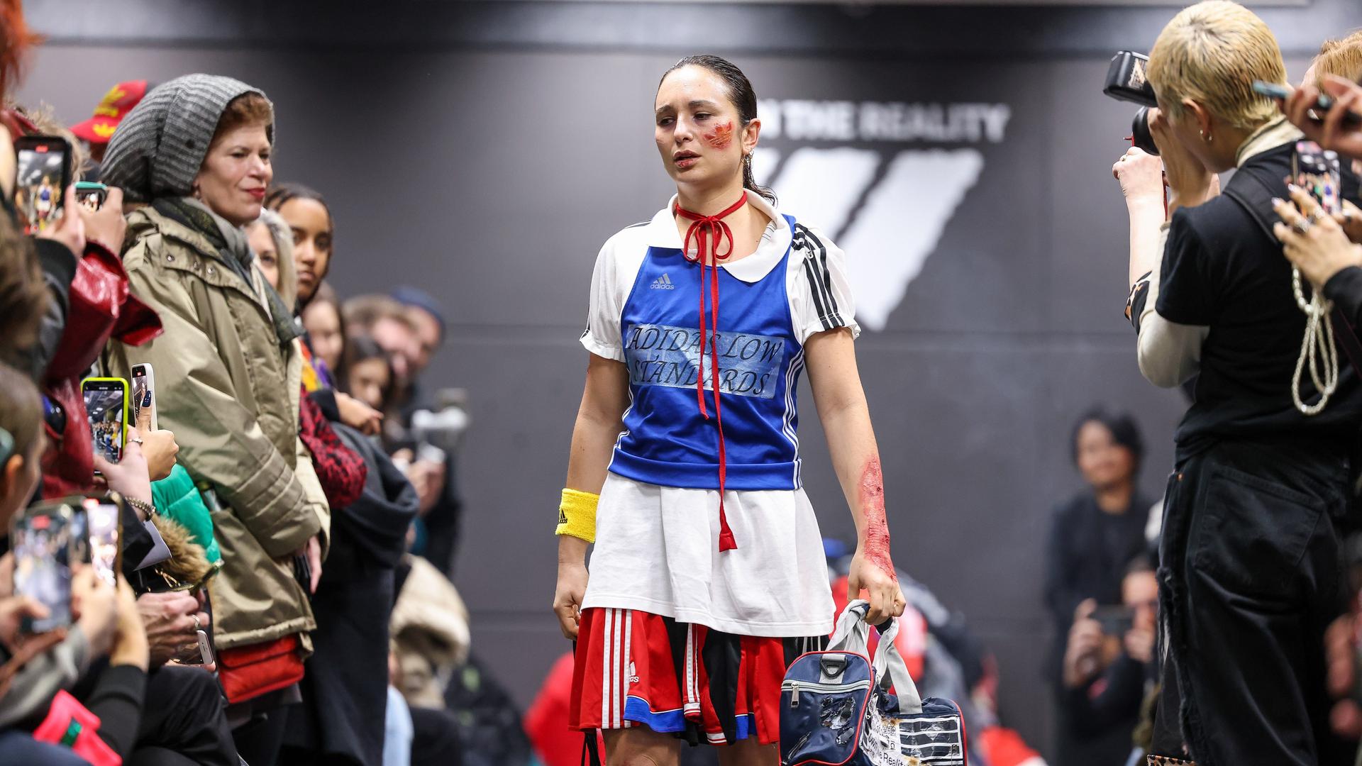Eine Aktivistin geht bei einer als Adidas-Show getarnten Performance im Rahmen der Berliner Fashion Week über den Laufsteg. 