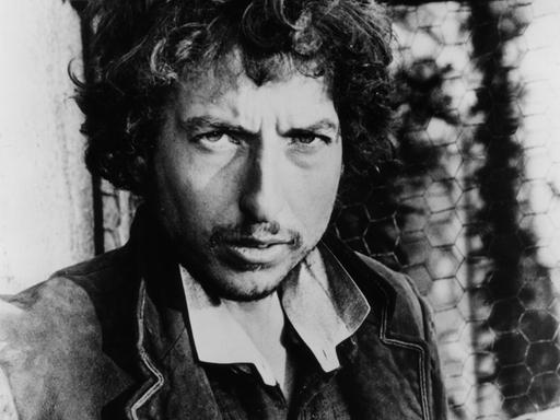 Schwarz-Weiß-Porträtfoto des US-Rocksängers Bob Dylan um 1975. Der Musiker schaut in die Kamera.