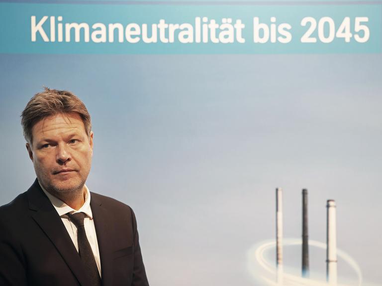 Robert Habeck (Bündnis 90/Die Grünen), Bundesminister für Wirtschaft und Klimaschutz, steht vor einem Plakat mit Aufschrift "Klimaneutralität bis 2045". 
