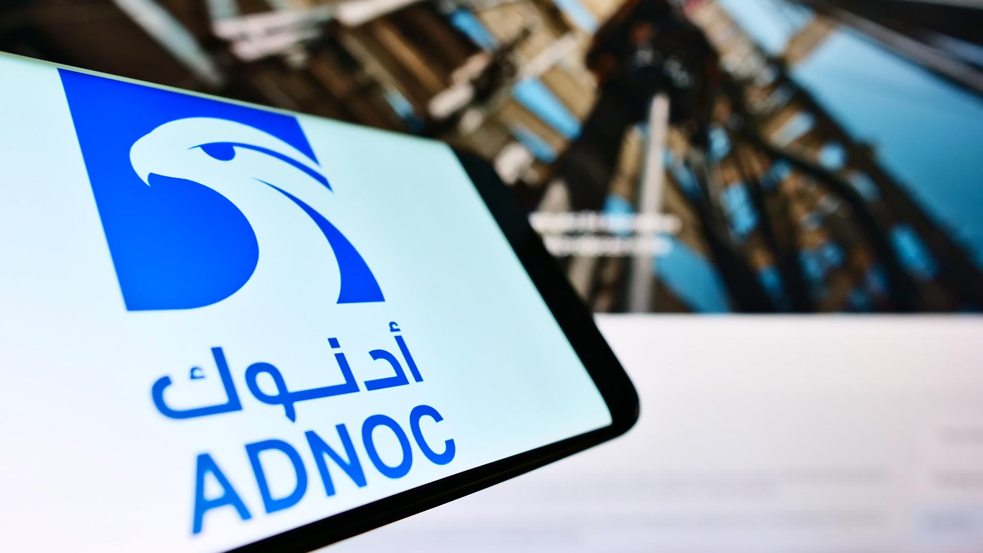 Ein mobiles Telefon mit Schriftzug des Abu Dhabi National Oil Company (ADNOC) Ein mobiles Telefon mit Schriftzug des Abu Dhabi National Oil Company (ADNOC)