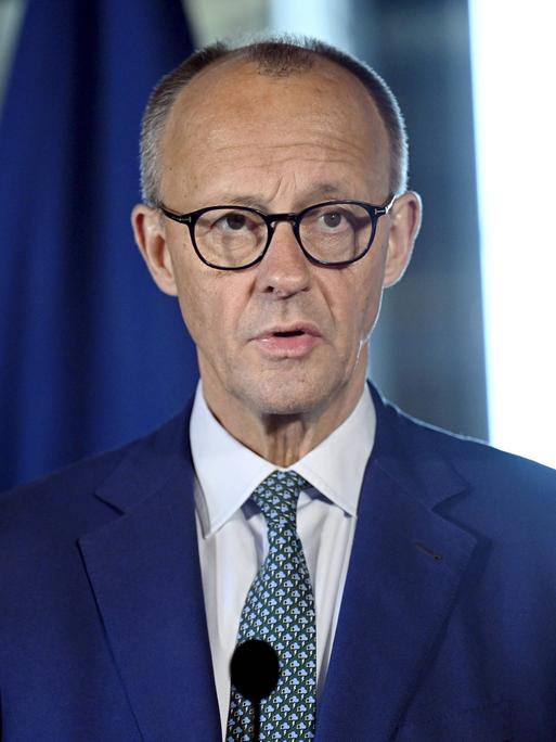 Friedrich Merz spricht bei einer Pressekonferenz in ein Mikrofon.