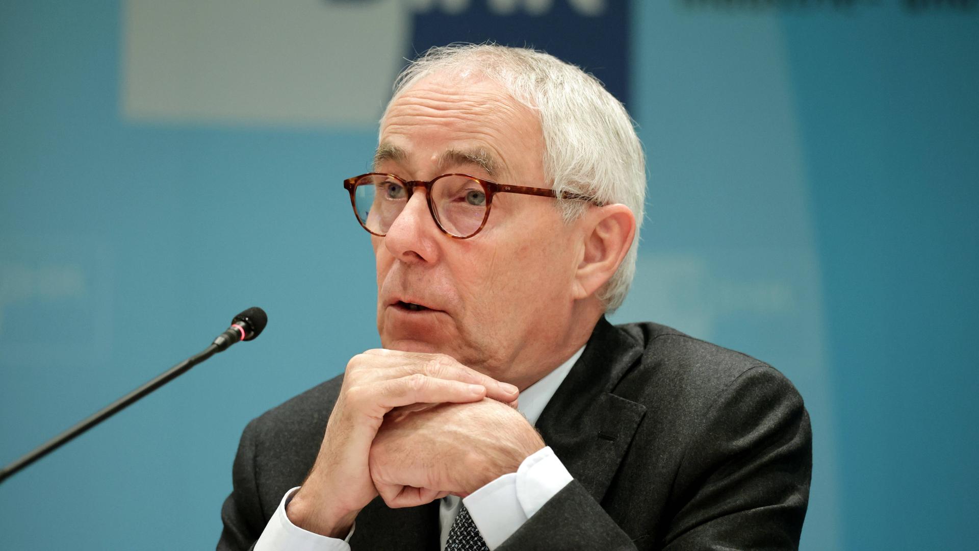 Peter Adrian, Präsident der Deutschen Industrie- und Handelskammer, sitzt vor einem Mikrofon. 