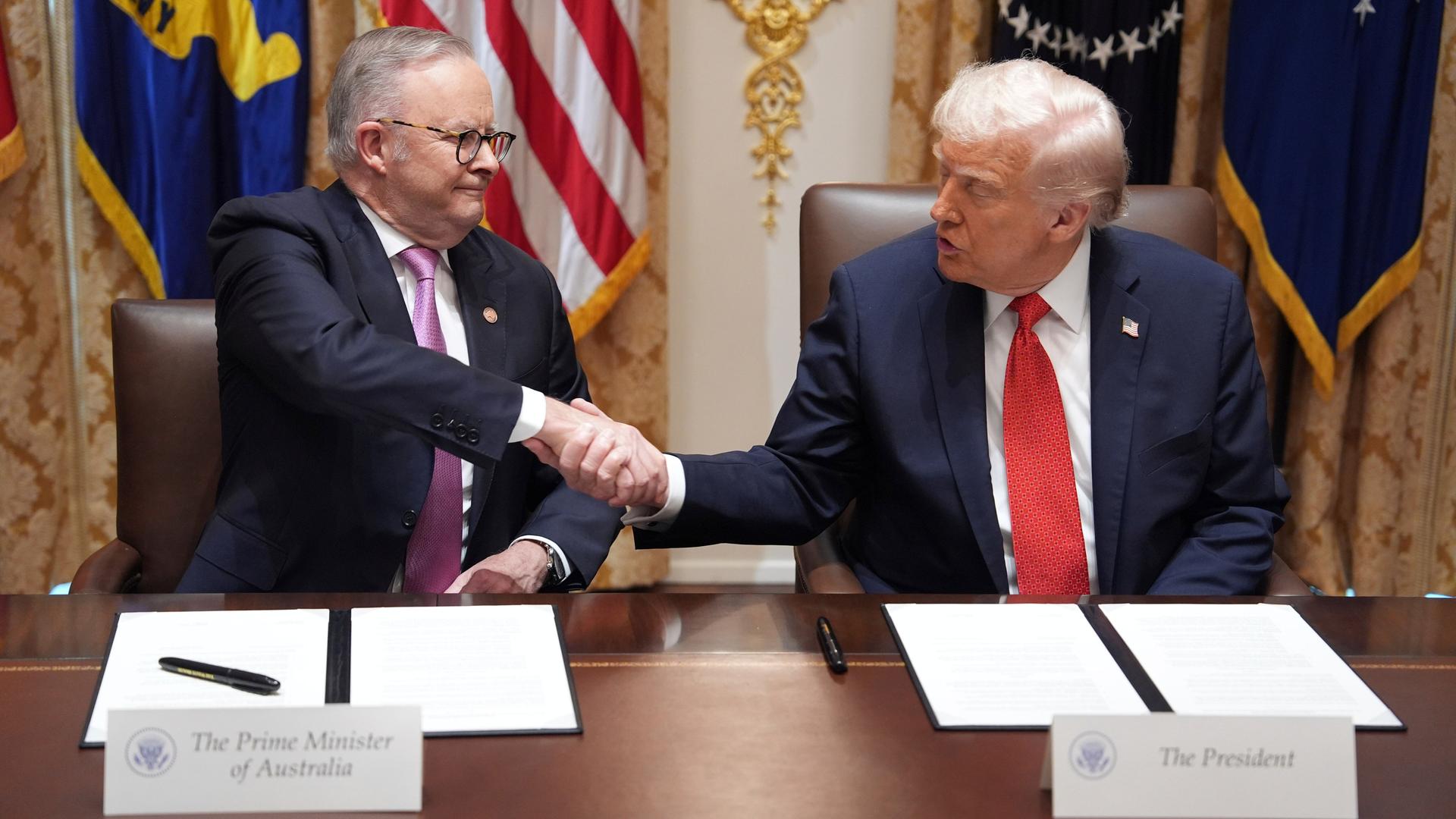US-Präsident Trump und der australische Premierminister Albanese sitzen nebeneinander und schütteln sich die Hand. US-Präsident Trump und der australische Premierminister Albanese sitzen nebeneinander und schütteln sich die Hand.