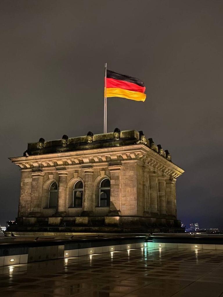 Die Deutschlandfahne auf dem Dach des Reichstages bei Nacht.