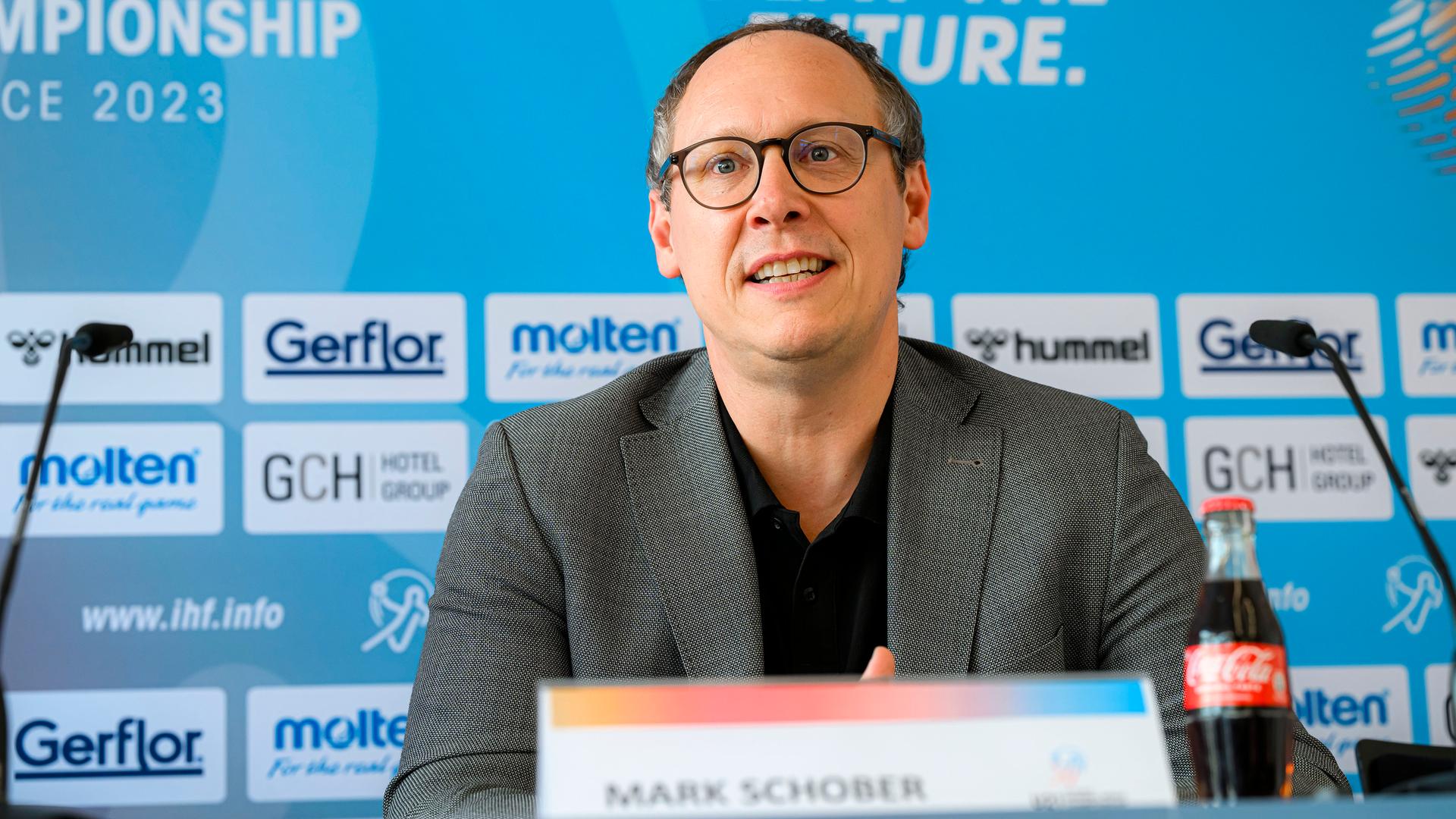 Mark Schober lächelt bei einer Pressekonferenz. Mark Schober lächelt bei einer Pressekonferenz.