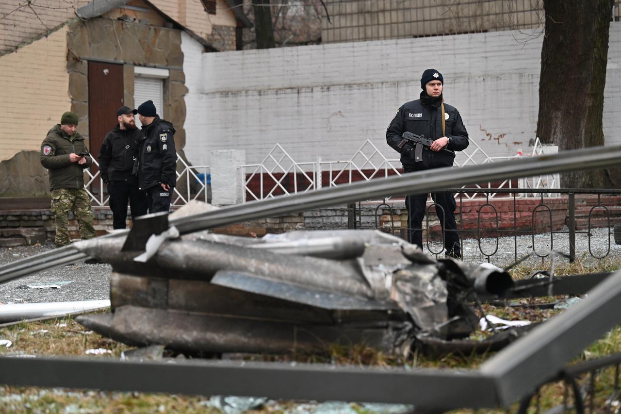 Ein Polizist in Kiew steht vor den Überresten einer Granate Wache.

