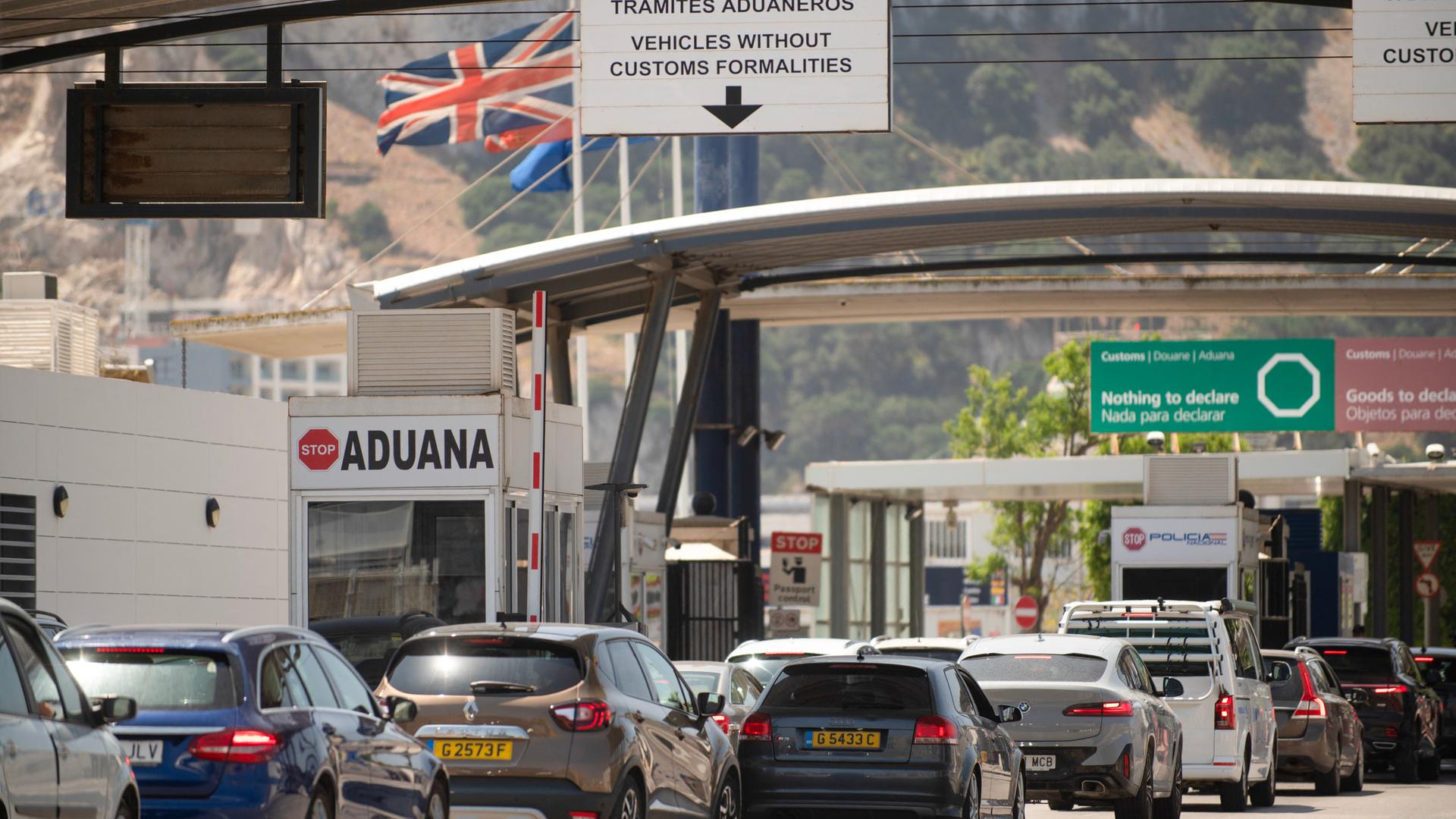 Fahrzeuge überqueren die Grenze von Spanien zu Gibraltar. Im Hintergrund weht die britische Flagge. Fahrzeuge überqueren die Grenze von Spanien zu Gibraltar. Im Hintergrund weht die britische Flagge.
