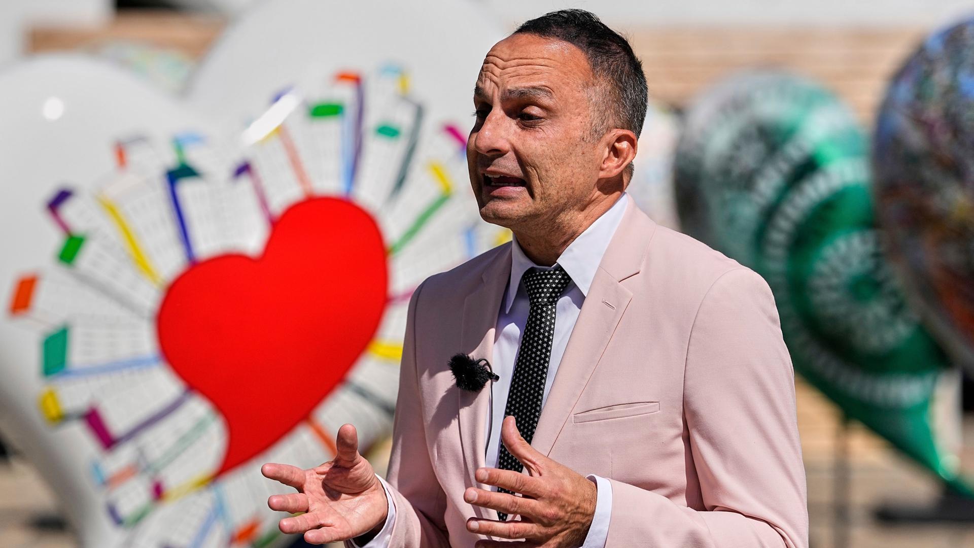 Der ESC-Experte Dean Vuletic gibt in der ESC-Woche am 16.5.2025 in Basel ein Interview. Im Hintergrung ist eine Deko mit bunten Herzen zu sehen.