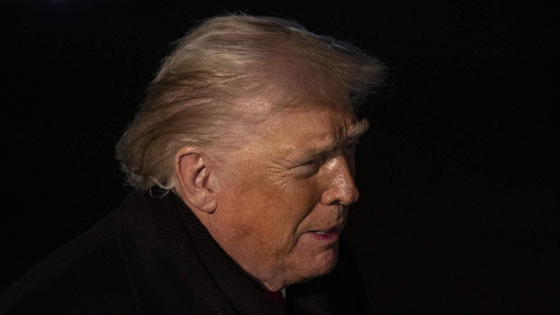 Profilaufnahme von US-Präsident Donald Trump in der Nacht. Es ist nur sein Gesicht von der Seite zu erkennen.