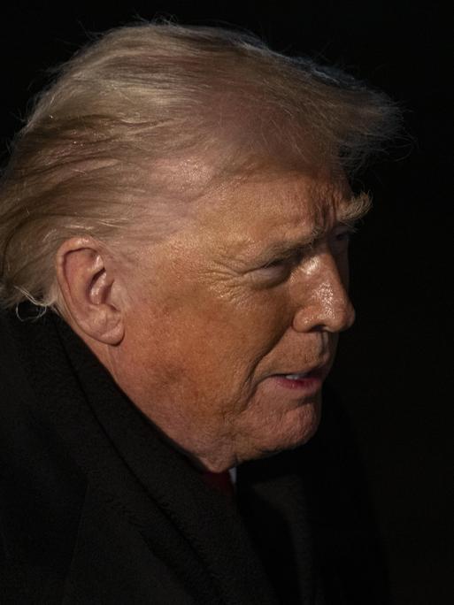 Profilaufnahme von US-Präsident Donald Trump in der Nacht. Es ist nur sein Gesicht von der Seite zu erkennen.