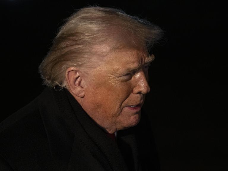 Profilaufnahme von US-Präsident Donald Trump in der Nacht. Es ist nur sein Gesicht von der Seite zu erkennen.