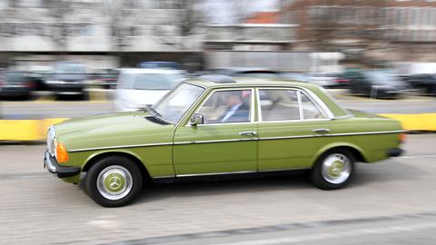 Ein als Oldtimer zugelassener Mercedes fährt durch eine Innenstadt