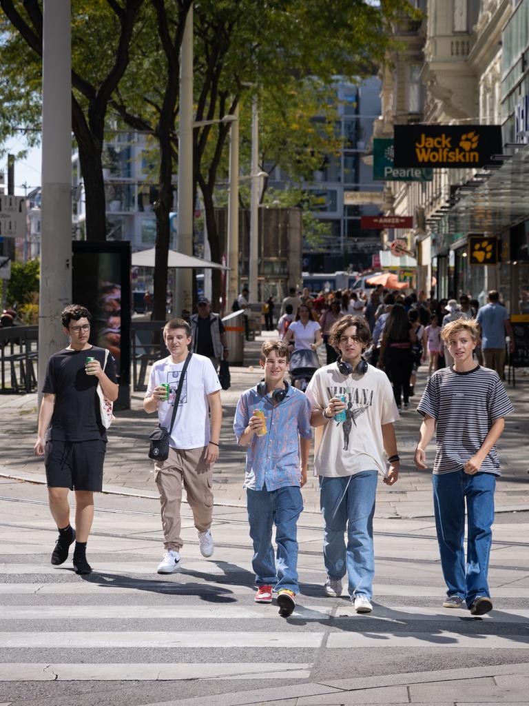 Jugendliche gehen eine Straße entlang.