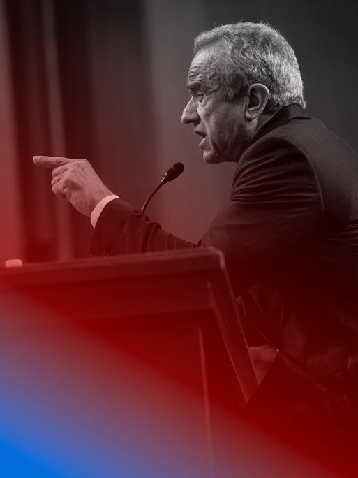 Blau eingefärbtes Bild von Robert F. Kennedy Jr. der gestikulierend an einem Rednerpult sitzt.