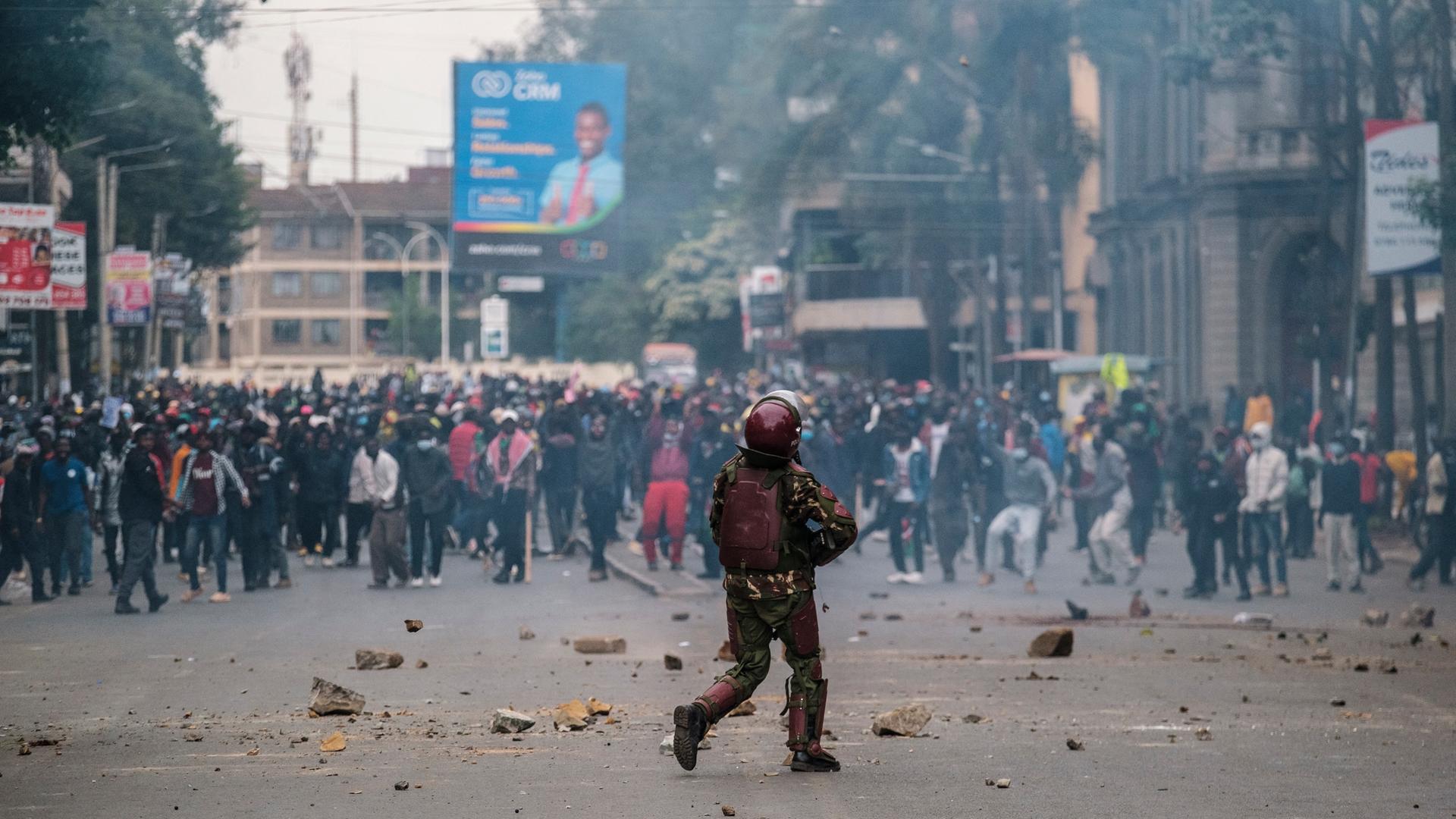 Ein Polizist steht Demonstranten in einer Straße in Nairobi gegenüber.