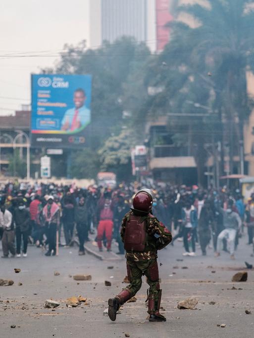 Ein Polizist steht Demonstranten in einer Straße in Nairobi gegenüber.