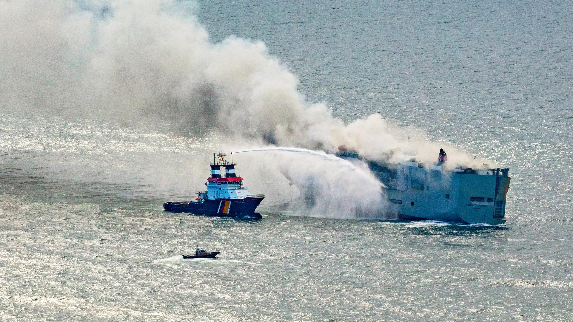 Der Schlepper Nordic löscht das Feuer auf einem Frachter vor Ameland in der Nordsee.