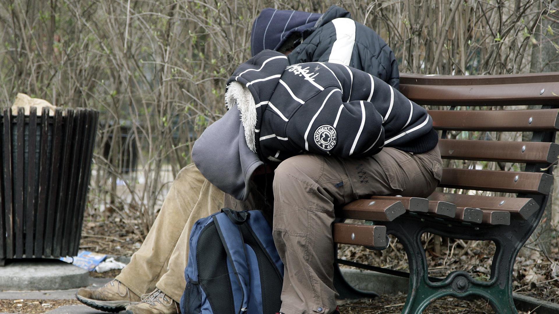Zwei Jugendliche schlafen auf einer Park-Bank in Berlin.