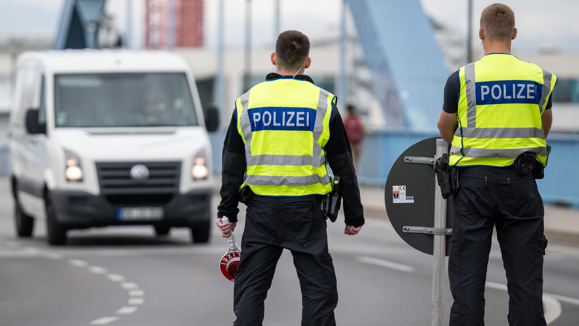 Zwei Polizisten stehen an der deutsch-polnischen Grenze.