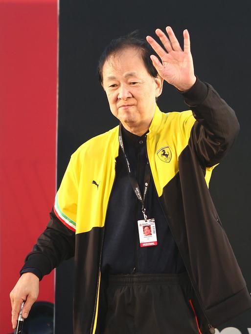 Das Bild zeigt den chinesischen Schauspieler und Regisseur Jimmy Wang Yu im Jahr 2013. Er winkt auf dem Foto jemandem zu.