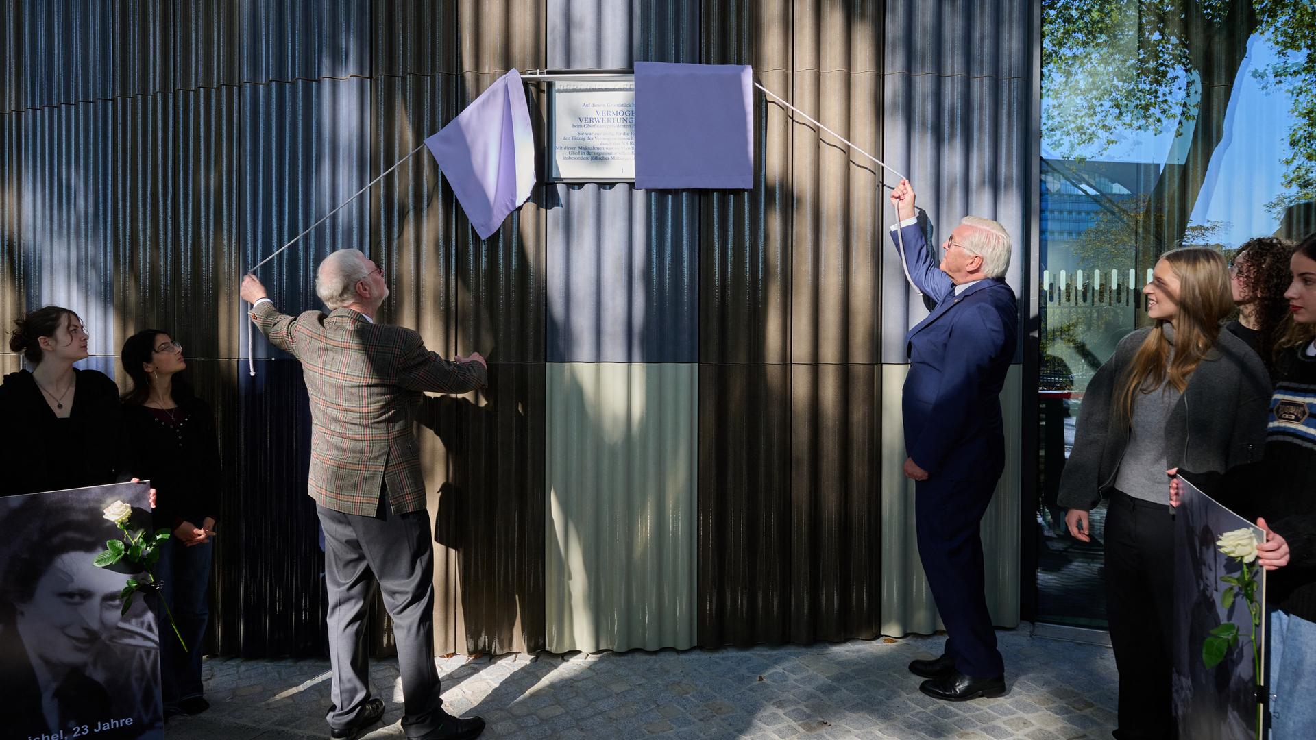 Thomas Abel (3.v.l.) vom Verein "Gleis 69" und Bundespräsident Frank-Walter Steinmeier enthüllen bei der Wiedereinweihung die Gedenktafel am Standort der einstigen Berliner Vermögensverwertungsstelle des NS-Regimes. Thomas Abel (3.v.l.) vom Verein "Gleis 69" und Bundespräsident Frank-Walter Steinmeier enthüllen bei der Wiedereinweihung die Gedenktafel am Standort der einstigen Berliner Vermögensverwertungsstelle des NS-Regimes.