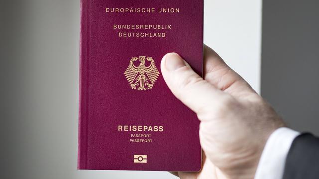 Jemand hält einen deutschen Reisepass in der Hand. 