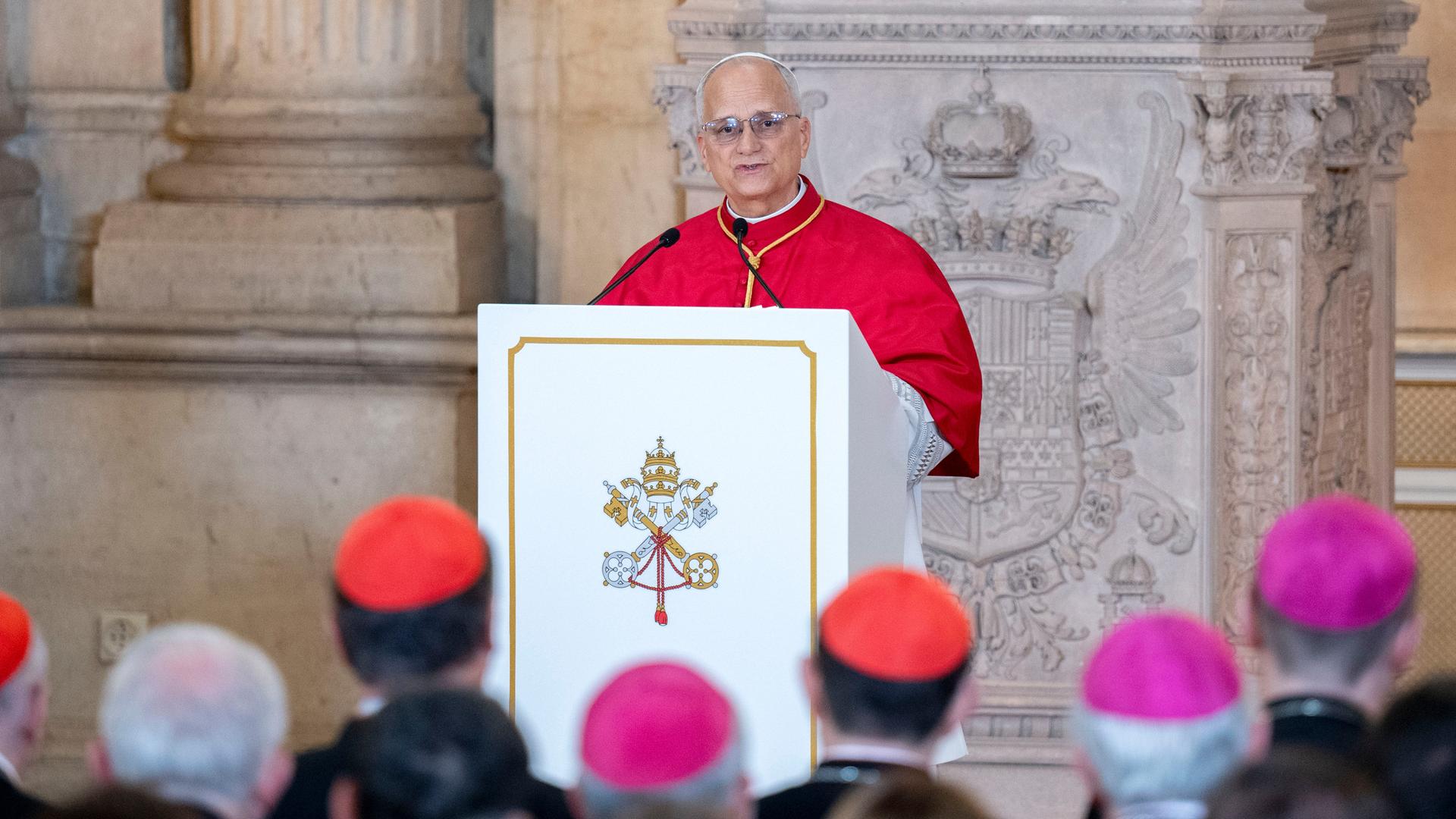 Das Bild zeigt Papst Leo XIV. an einem Redepult. Er spricht zu zahlreichen Zuhörern. die schemenhaft im Vordergrund zu sehen sind. Das Bild zeigt Papst Leo XIV. an einem Redepult. Er spricht zu zahlreichen Zuhörern. die schemenhaft im Vordergrund zu sehen sind.