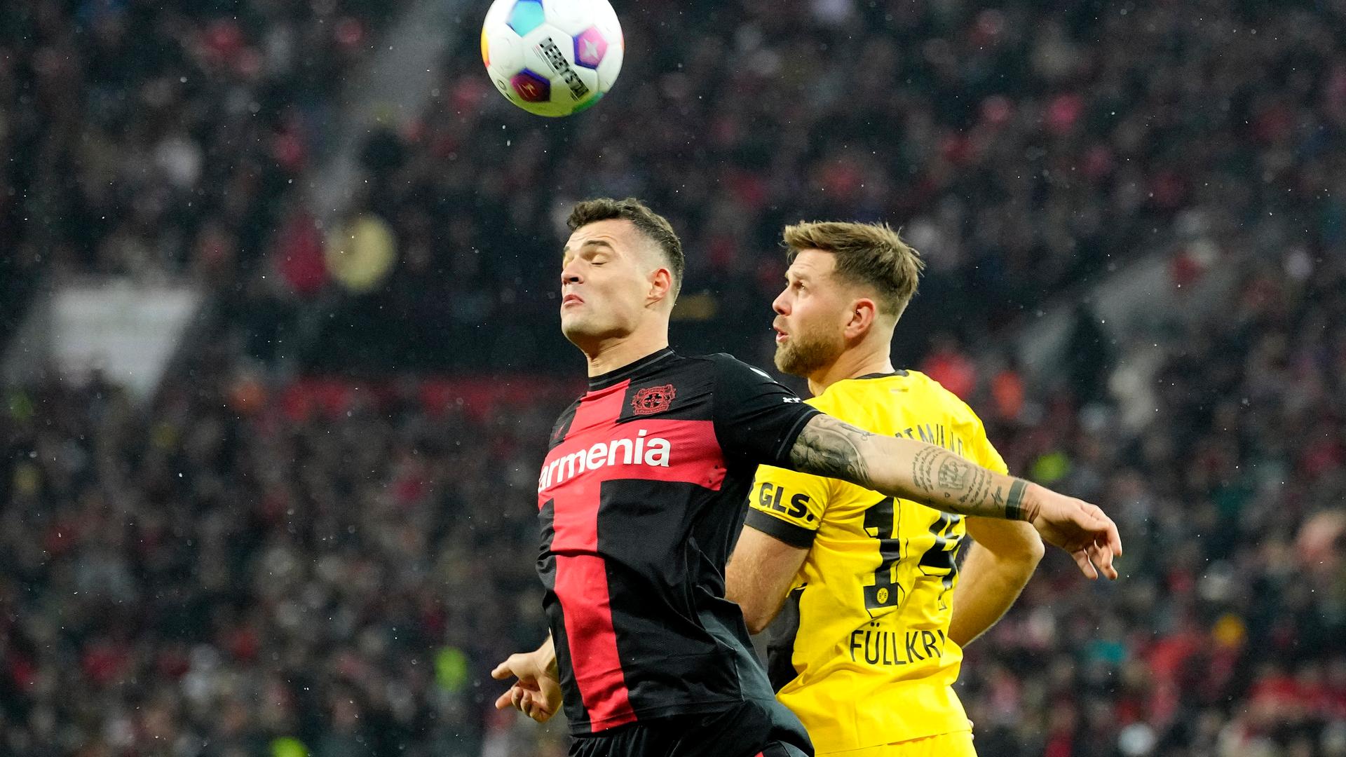 Leverkusens Granit Xhaka (l.) und der Dortmunder Niclas Füllkrug kämpfen um den Ball.