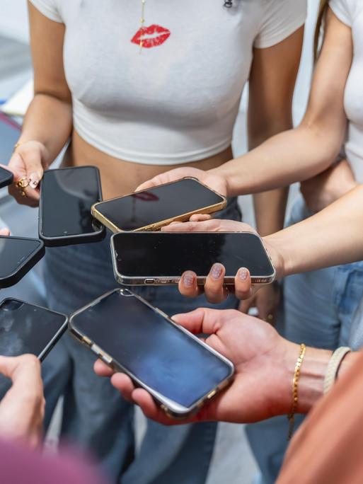 Jugendliche halten viele Mobiltelefone in der Hand, bilden mit ihren Händen einen Kreis. Jugendliche halten viele Mobiltelefone in der Hand, bilden mit ihren Händen einen Kreis.