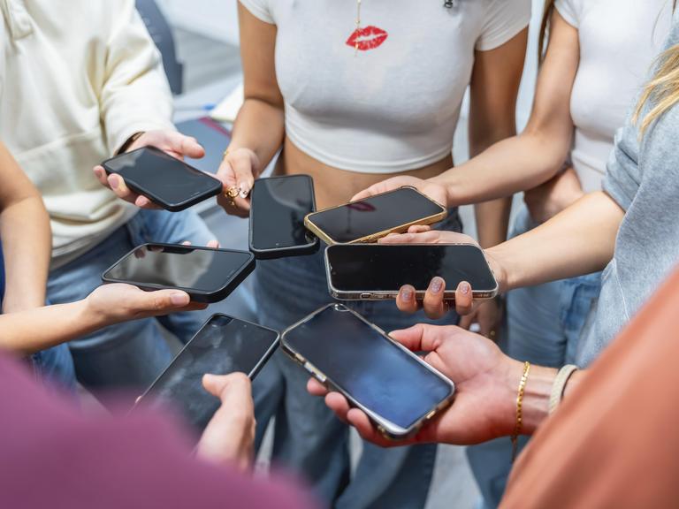 Jugendliche halten viele Mobiltelefone in der Hand, bilden mit ihren Händen einen Kreis. Jugendliche halten viele Mobiltelefone in der Hand, bilden mit ihren Händen einen Kreis.