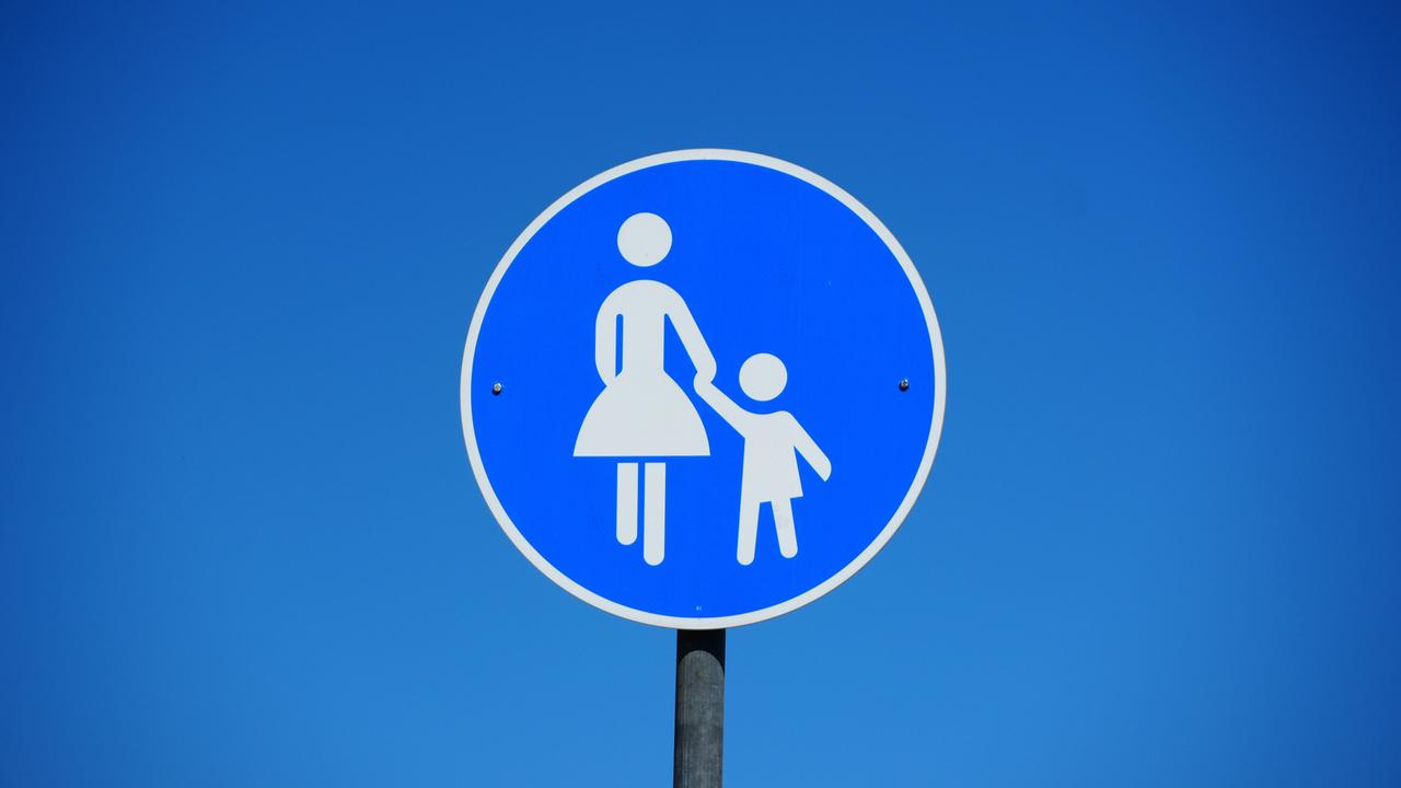 Blaues rundes Verkehrsschild mit einer Frau die ein Kind an der Hand hält als Hinweisschild für einen Gehweg