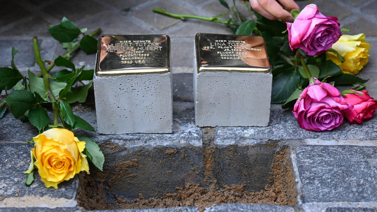 Zwei neue Stolpersteine werden in Kopfsteinpflaster verlegt.